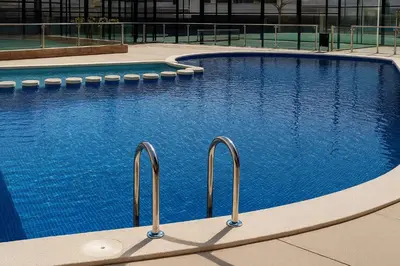 a large swimming pool with blue water in a building at Resort & Suites Ciudad de las Ciencias By VALENCIAFLATS EU in Valencia