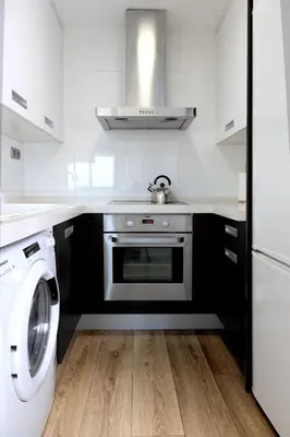 a kitchen with a stove and a washing machine at Resort & Suites Ciudad de las Ciencias By VALENCIAFLATS EU in Valencia