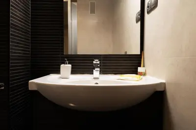 a white sink in a bathroom with a mirror at Resort & Suites Ciudad de las Ciencias By VALENCIAFLATS EU in Valencia