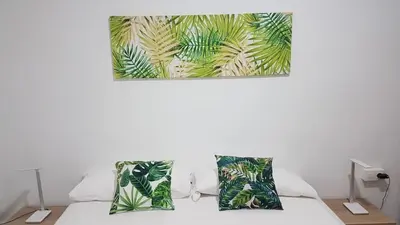 a bed with two pillows and a painting on the wall at Malva Arena in Valencia