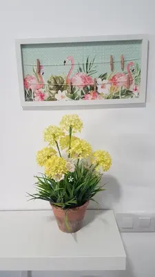 a vase of flowers on a table with a picture of flamingos at Malva Arena in Valencia