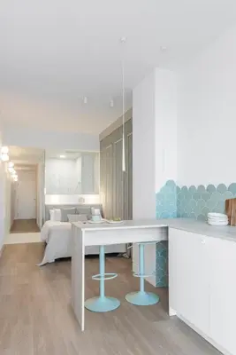 a kitchen with a table and a living room at Designer apartment facing the sea in Valencia