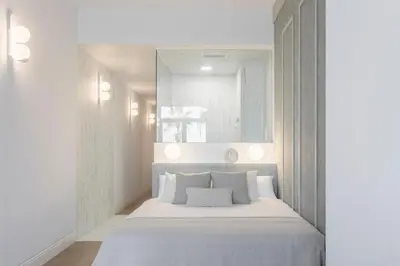 a bedroom with a white bed and a mirror at Designer apartment facing the sea in Valencia