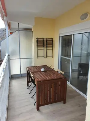 a room with a table and chairs on a balcony at Edificio JUNIOR in Cullera