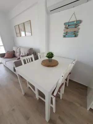 a white dining room with a white table and chairs at Edificio JUNIOR in Cullera