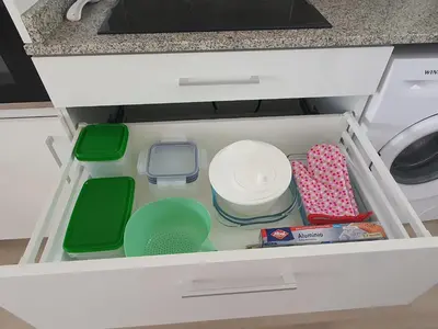 a drawer filled with dishes and other kitchen utensils at Edificio JUNIOR in Cullera