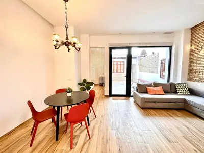 a living room with a table and chairs and a couch at Mediterranean Apartament in Valencia