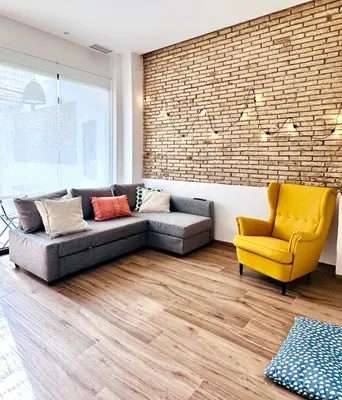 a living room with a couch and a yellow chair at Mediterranean Apartament in Valencia