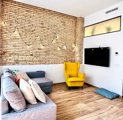 a living room with a couch and a tv at Mediterranean Apartament in Valencia