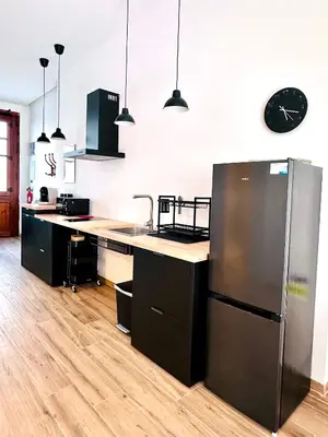 a kitchen with a stainless steel refrigerator and a clock on the wall at Mediterranean Apartament in Valencia