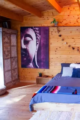 a bedroom with a bed with a large painting on the wall at Cabaña madera en bosque 100 ECO in Petrés