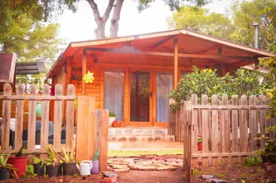 a wooden cabin with a fence in front of it at Cabaña madera en bosque 100 ECO in Petrés