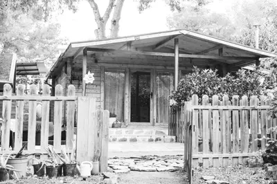 a wooden cabin with a fence in front of it at Cabaña madera en bosque 100 ECO in Petrés