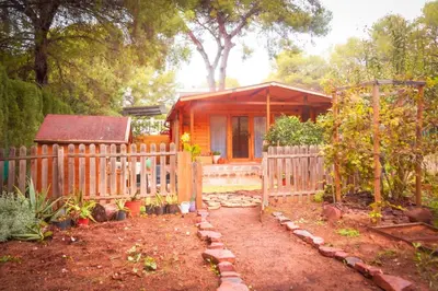a wooden fence in front of a small house at Cabaña madera en bosque 100 ECO in Petrés
