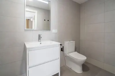 a bathroom with a toilet and a sink and a mirror at VLC Host - Sumsi in Valencia