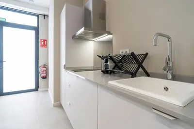 a white kitchen with a sink and a counter at VLC Host - Sumsi in Valencia