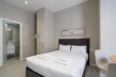 a bedroom with a large white bed and a table at VLC Host - Sumsi in Valencia