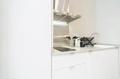 a white kitchen with a sink and a stove at VLC Host - Sumsi in Valencia