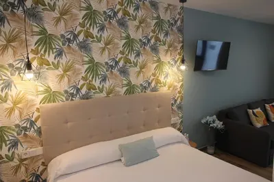 a bedroom with a bed and a wall with a tropical wallpaper at Ruzafa Acquamarina in Valencia