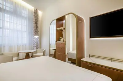 a hotel room with a bed and a large window at Grand Hotel Centenari, Valencia, Autograph Collection in Valencia