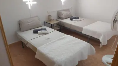 a room with two beds and a mirror at Apartamento amanecer paseo marítimo in Cullera