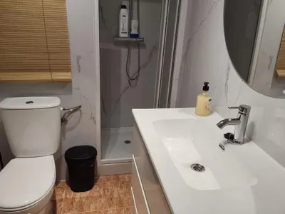 a bathroom with a sink and a toilet and a mirror at Apartamento amanecer paseo marítimo in Cullera