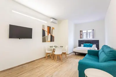 a living room with a blue couch and a bed at The Port Urban Loft in Valencia