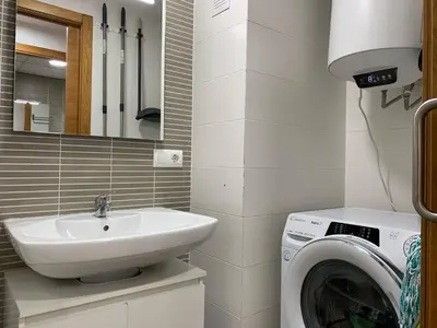 a bathroom with a sink and a washing machine at Sunrise Beach Apartment Playa Puerto de Sagunto in Puerto de Sagunto