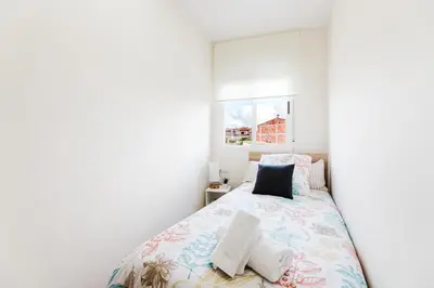 a bedroom with a bed with white walls and a window at Casa Las 4 Estaciones in Caudiel