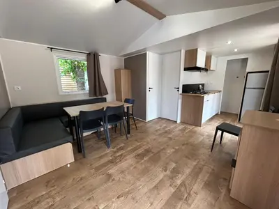 a living room with a table and chairs and a kitchen at Camping Los Naranjos in Moncófar