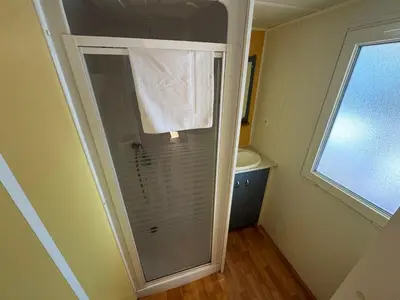 a bathroom with a shower with a white towel at Camping Los Naranjos in Moncófar