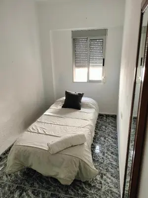 a bed in a room with a pillow on it at Calle platano37 in Valencia