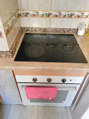 a kitchen counter with a stove with a red towel at Calle platano37 in Valencia
