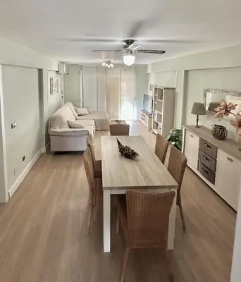 a dining table and chairs in a living room at Apartamento Bahía Cullera I in Cullera