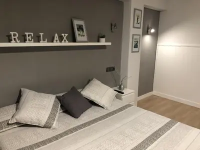 a bedroom with a bed with white sheets and pillows at Apartamento Bahía Cullera I in Cullera