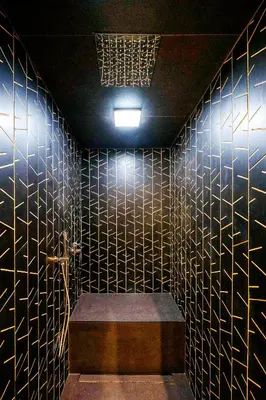 a bathroom with black tiled walls with a bench and lights at Hotel Pathos by Mimood Aparthotels in Valencia