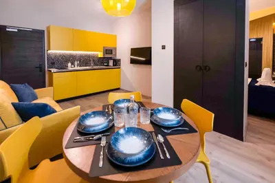 a dining room with a table and yellow chairs at Hotel Pathos by Mimood Aparthotels in Valencia