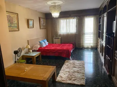 a bedroom with a bed with a red bedspread at Habitación central en piso compartido en valencia in Valencia