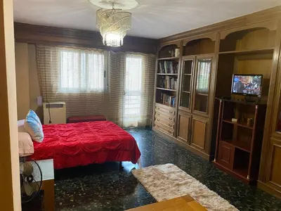a bedroom with a bed with a red comforter at Habitación central en piso compartido en valencia in Valencia