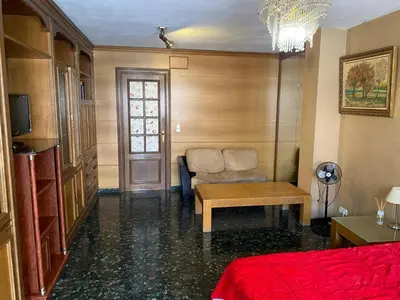 a room with a bed and a chair and a table at Habitación central en piso compartido en valencia in Valencia