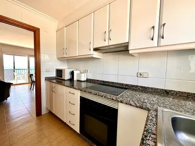 a kitchen with white cabinets and a counter top at Vistas al mar, El Puig in El Puig