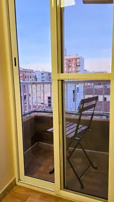 a chair on a balcony with a view of a city at Sagunto Beach Apartment 500m to Sea, WiFi 600Mb y AC in Puerto de Sagunto