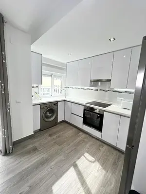 a kitchen with white cabinets and a washer and dryer at Cullera Sea and Mountain Balcony in Cullera