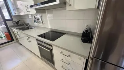 a kitchen with a sink and a stainless steel refrigerator at Apartment 300 m from the beach ,parking , breakfast in Valencia