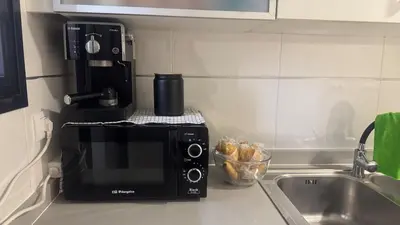 a microwave sitting on a kitchen counter next to a sink at Apartment 300 m from the beach ,parking , breakfast in Valencia