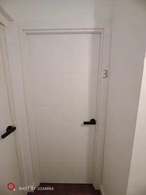 a white door with black handles in a room at Royal Lux in Sagunto