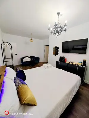 a bedroom with a large white bed with a chandelier at Royal Lux in Sagunto