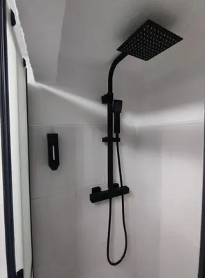 a shower in a bathroom with a black shower head at La Casita de Cullera in Cullera
