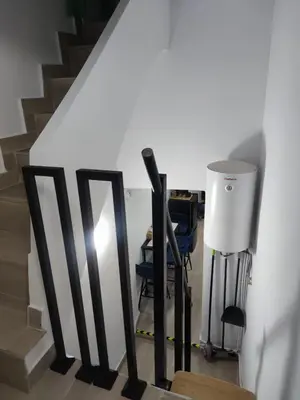 a staircase with black railings and a table and chairs at La Casita de Cullera in Cullera