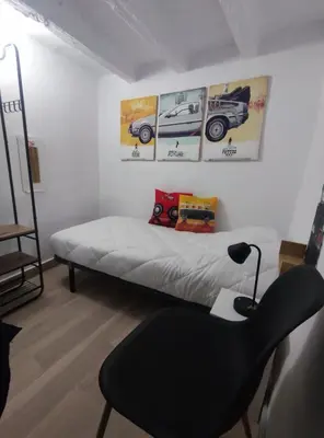 a bedroom with a bed and a desk and a chair at La Casita de Cullera in Cullera